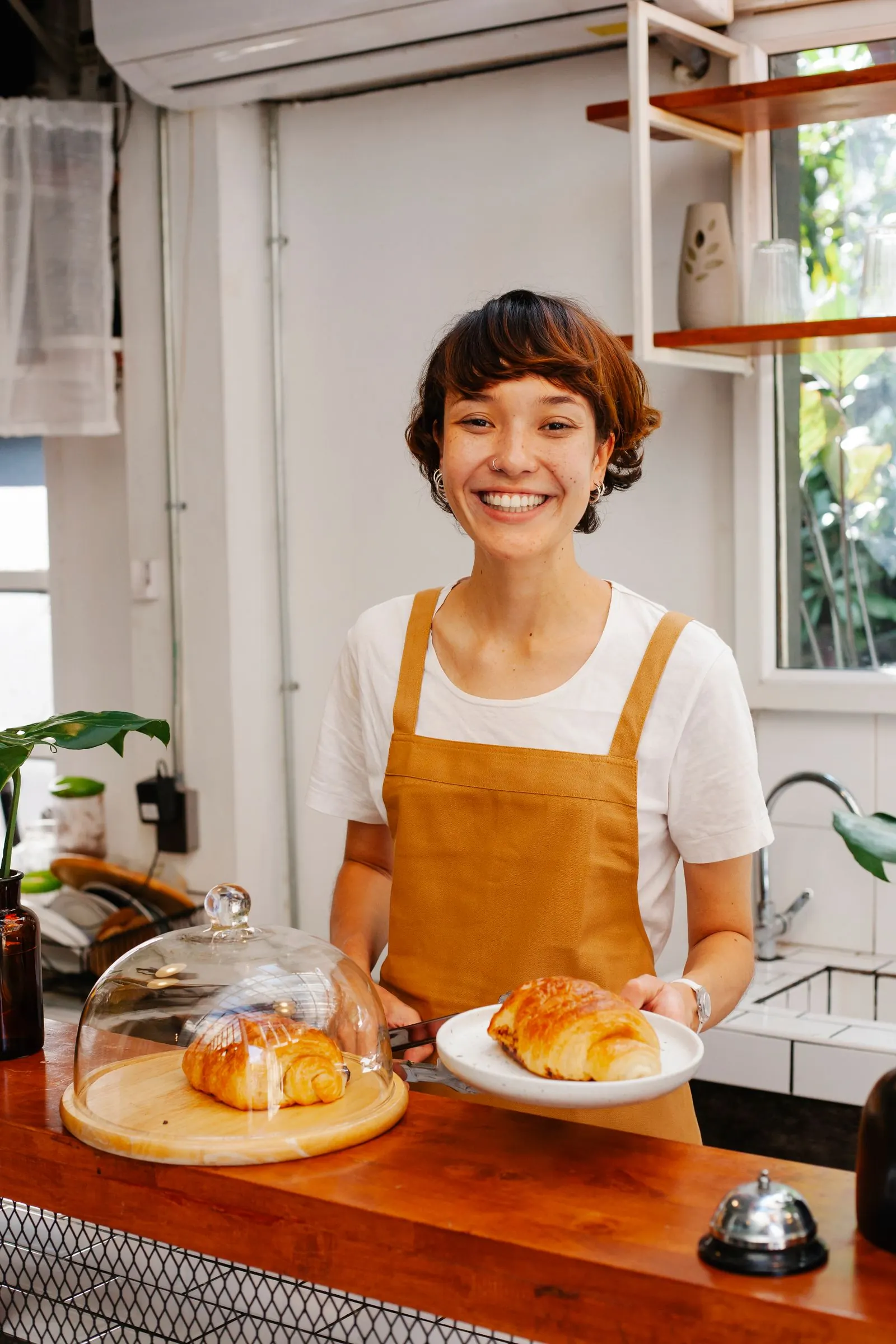 Café owner serving fresh croissants at the counter